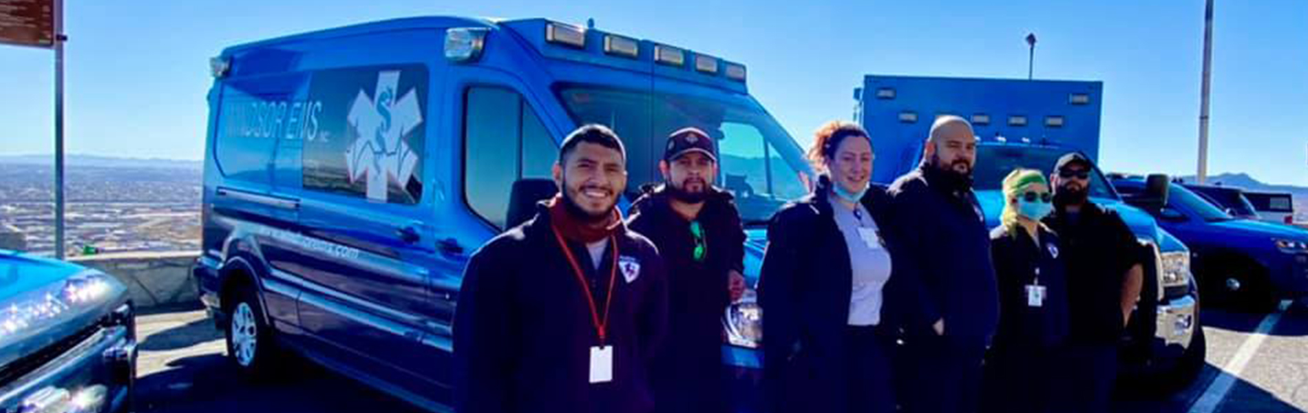 people in front of windsor ems vehicles