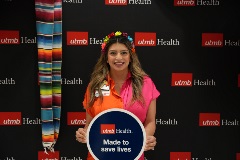 Clarissa Ortiz, UTMB Employee, posing with sign that says "made to save lives"