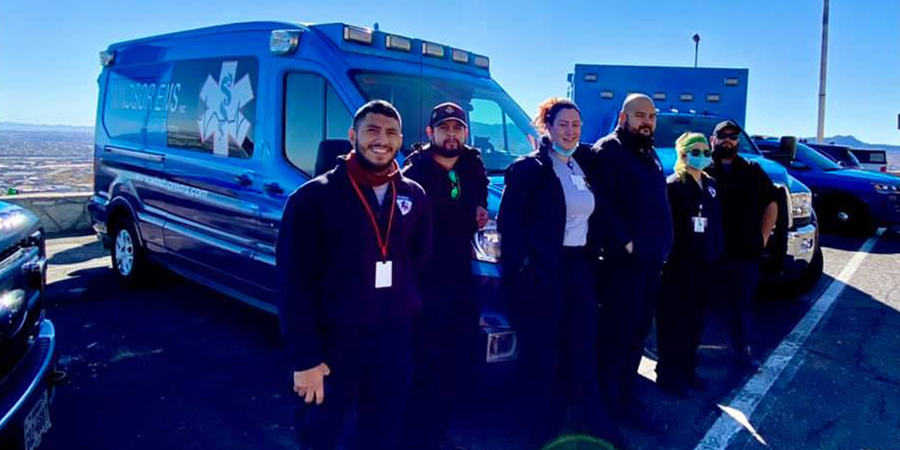 Individuals standing in front of Windsor EMS vehicles.