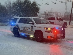 white and yellow emergency response vehicle driving on icy and snowy streets. they have their blue and red lights on the car and text on vehicle says "La Porte EMS" and "supervisor"