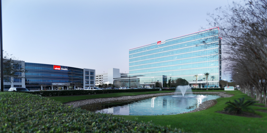 image of two buildings sitting perpendicular to themselves. There's a small pond with a fountain out front