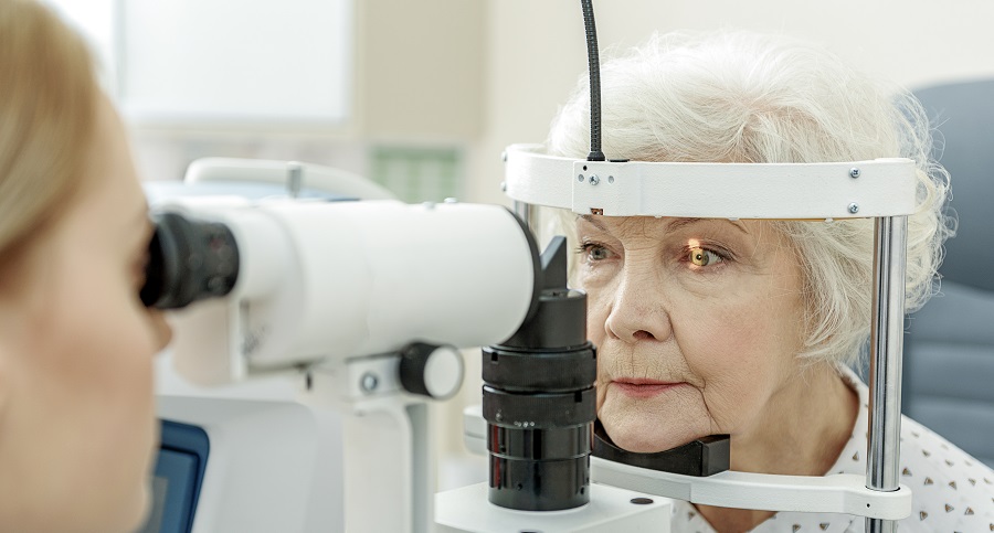 older Caucasian woman having her eyes examined by a doctor using a machine