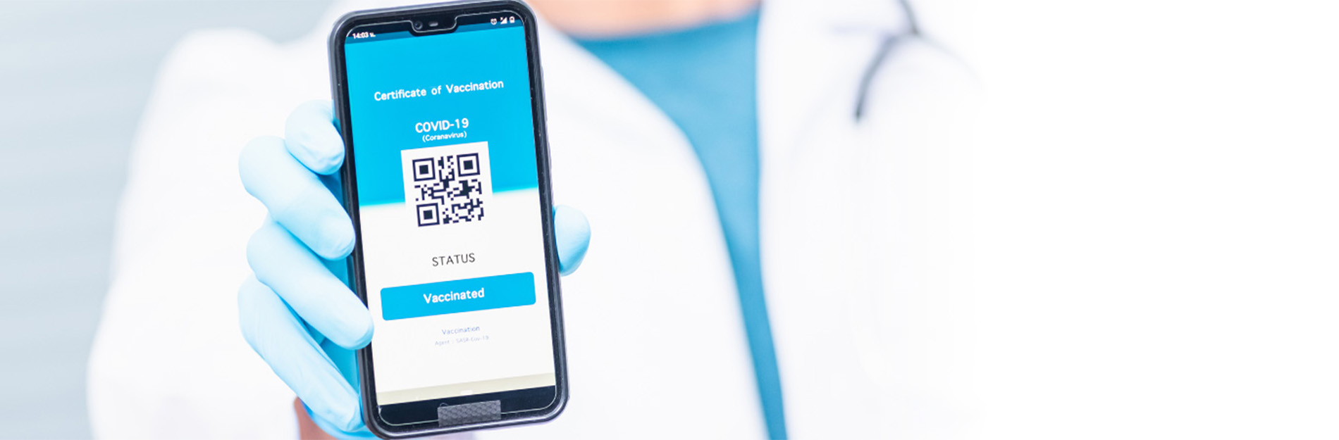 Medical personel holding up a phone with a QR code on the screen