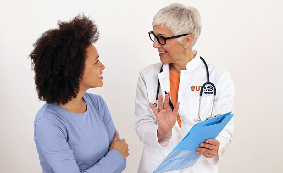 Female UTMB Health doctor and female patient having happy discussion