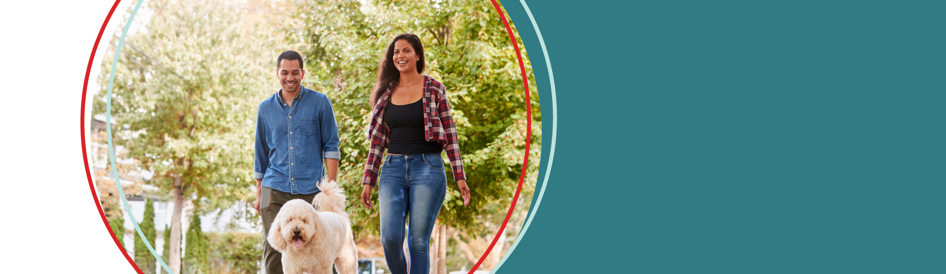 A woman and man walk a dog outside