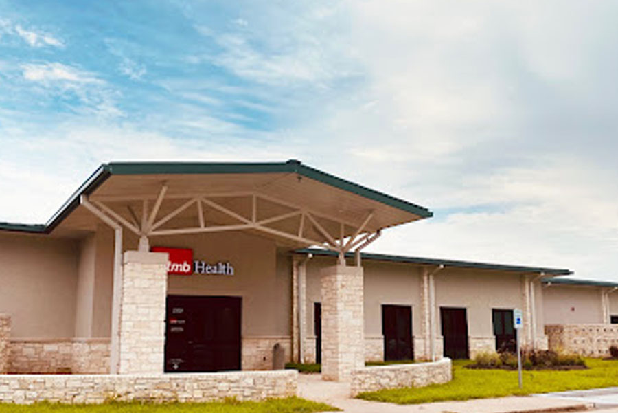 Exterior of UTMB Health Urgent Care clinic in Angleton on partially cloudy day