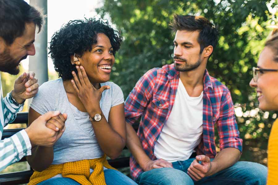 Women with hearing-aid talking to her friends