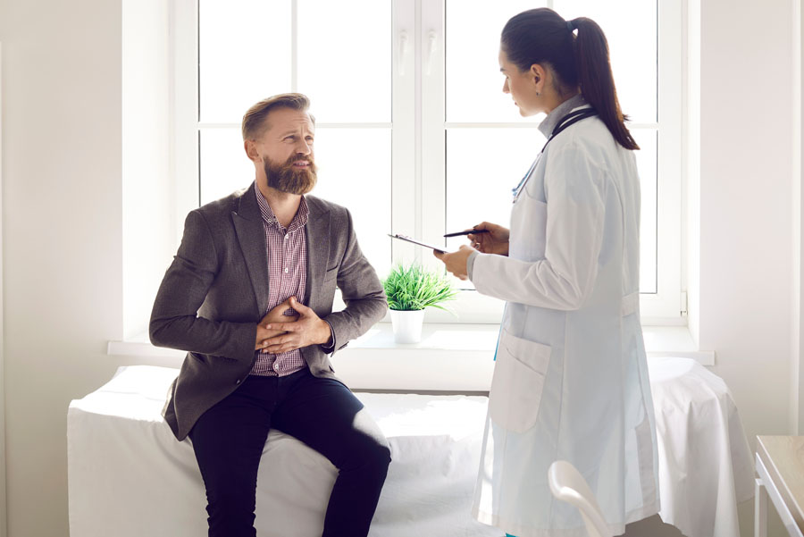 Female gastroenterologist meeting with male patient with stomach pain