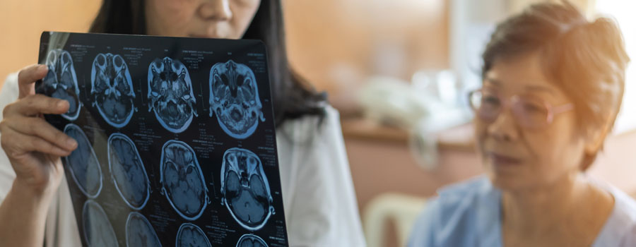 A healthcare provider reviews brain scan images with an older adult during a memory and cognitive evaluation.