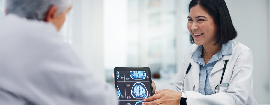 A neurosurgeon reviews brain imaging with a patient while discussing epilepsy surgery options at UTMB Health.