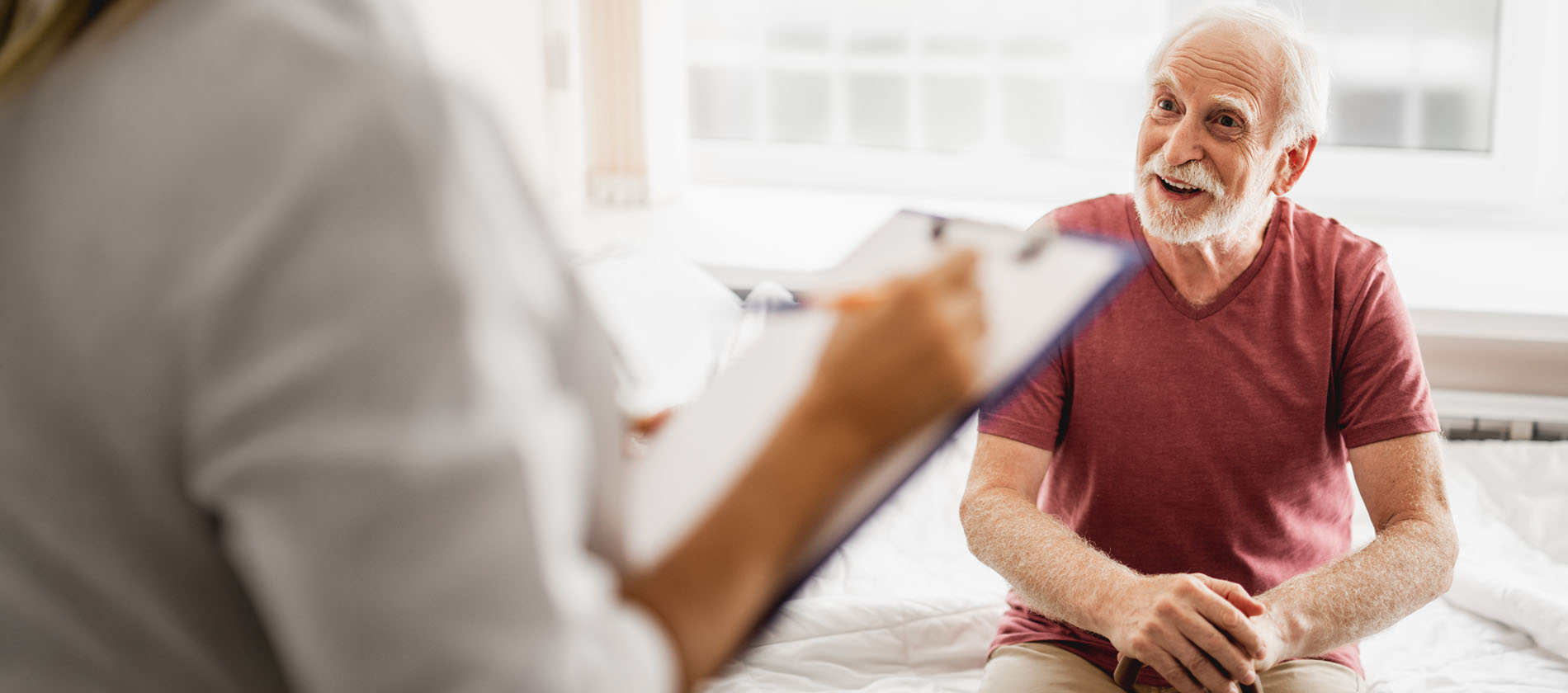 A neurosurgery provider listens as an older adult discusses symptoms during an initial screening evaluation at UTMB Health.