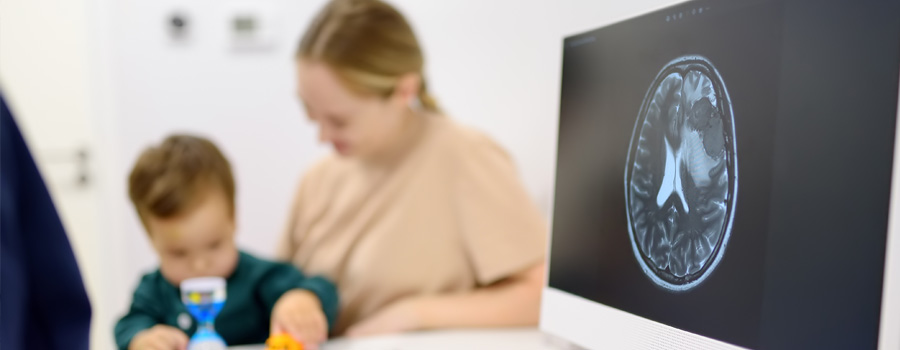 A caregiver and child meet with a care team as brain imaging is reviewed for pediatric epilepsy surgery at UTMB Health.