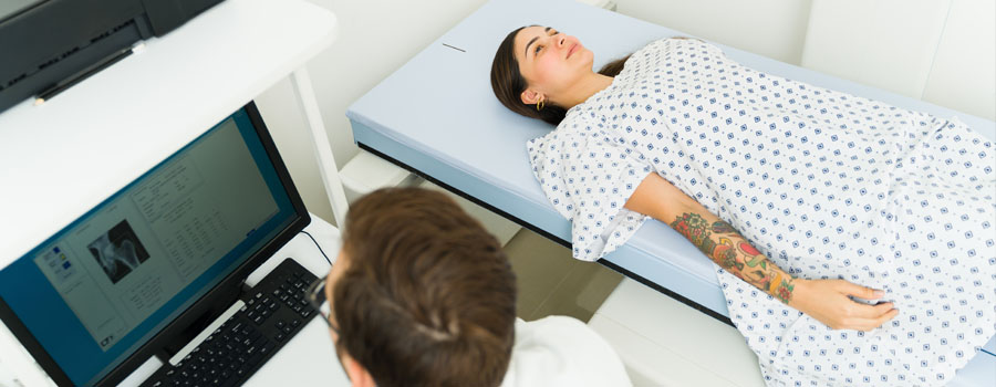 Woman patient getting a diagnosis with a densitometry X-ray test, bone density test, at UTMB Health.