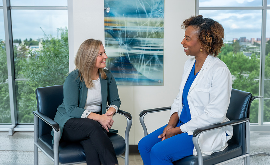 Female patient sitting and talking with female doctor at UTMB Health