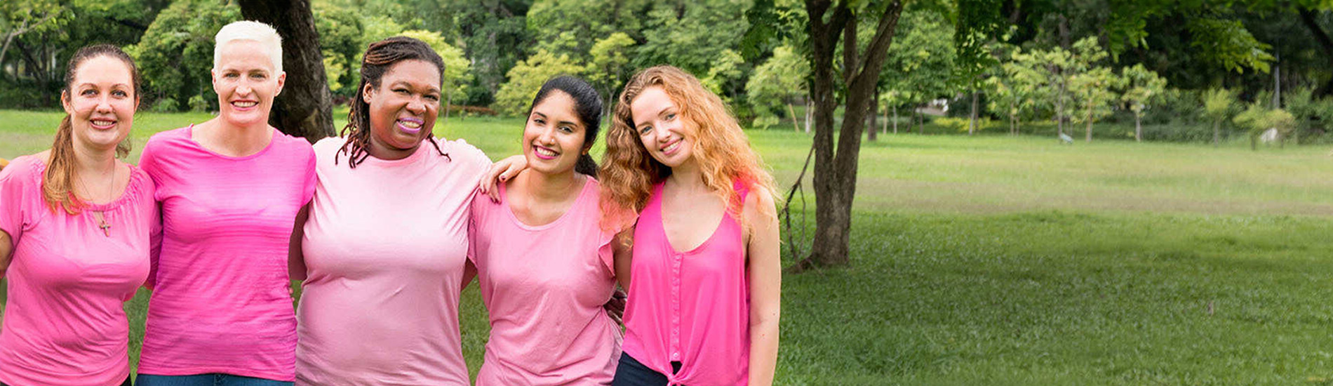 Five women wearing pink embracing each other