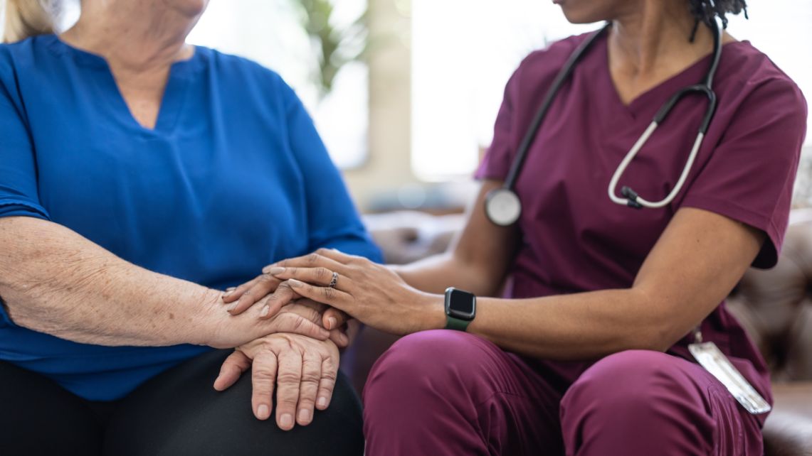 A nurse holding hands with a patient