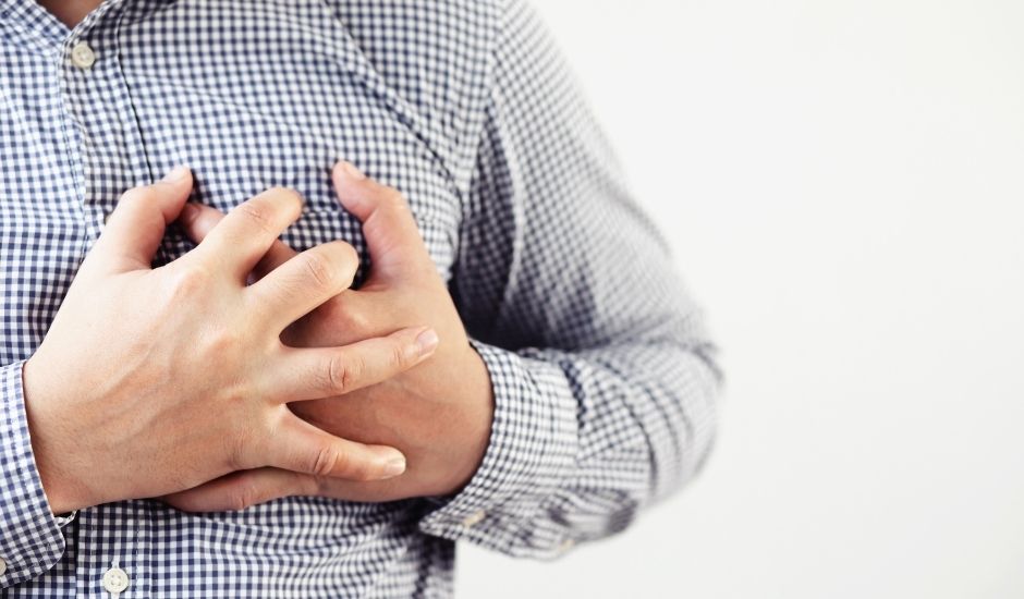 A man cluctching his chest during a heart attack