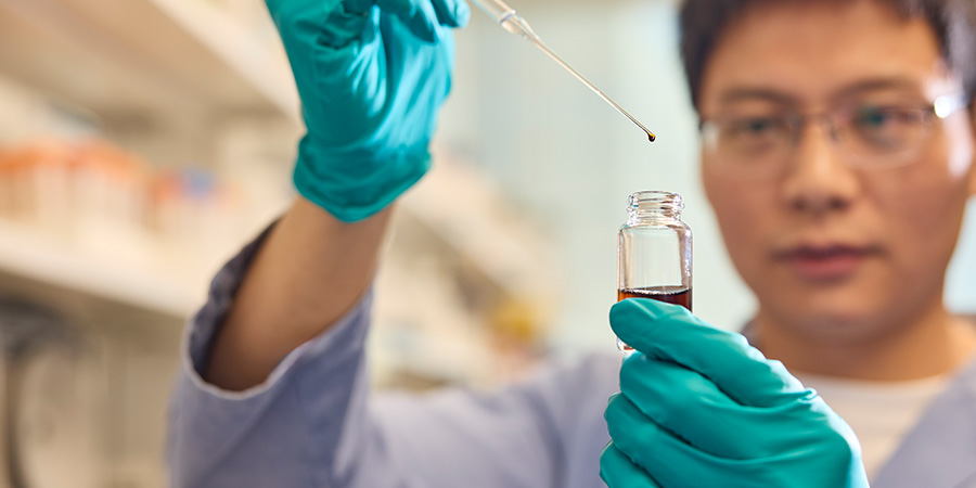 Individual holding Ibogaine dropper in lab