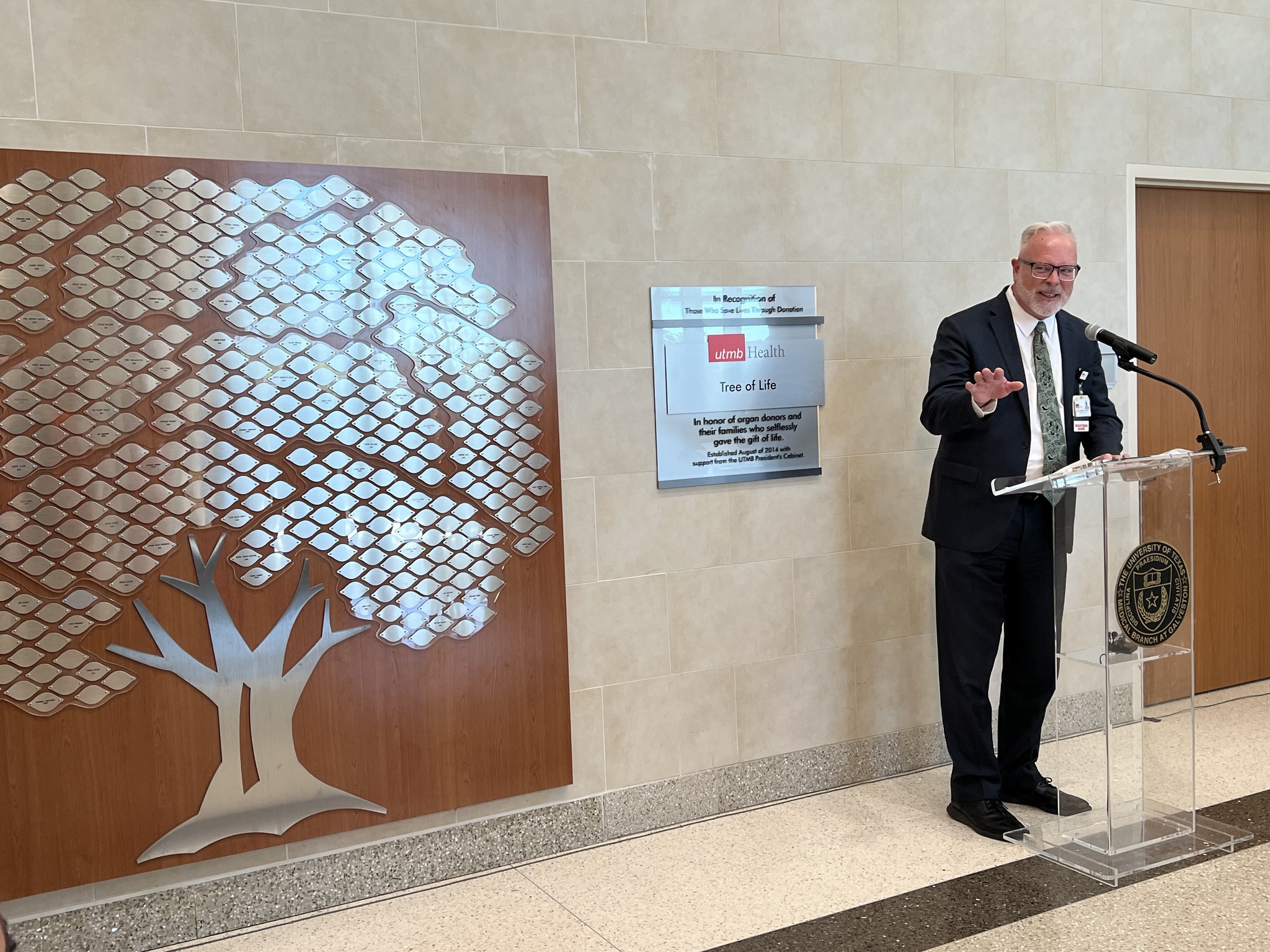 Dr. Mansfield speaks about organ donation in front of the Tree of Life display