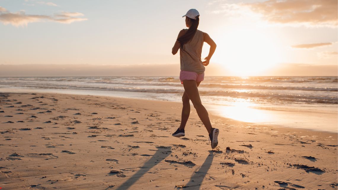 A woman running on the beach at sunrise