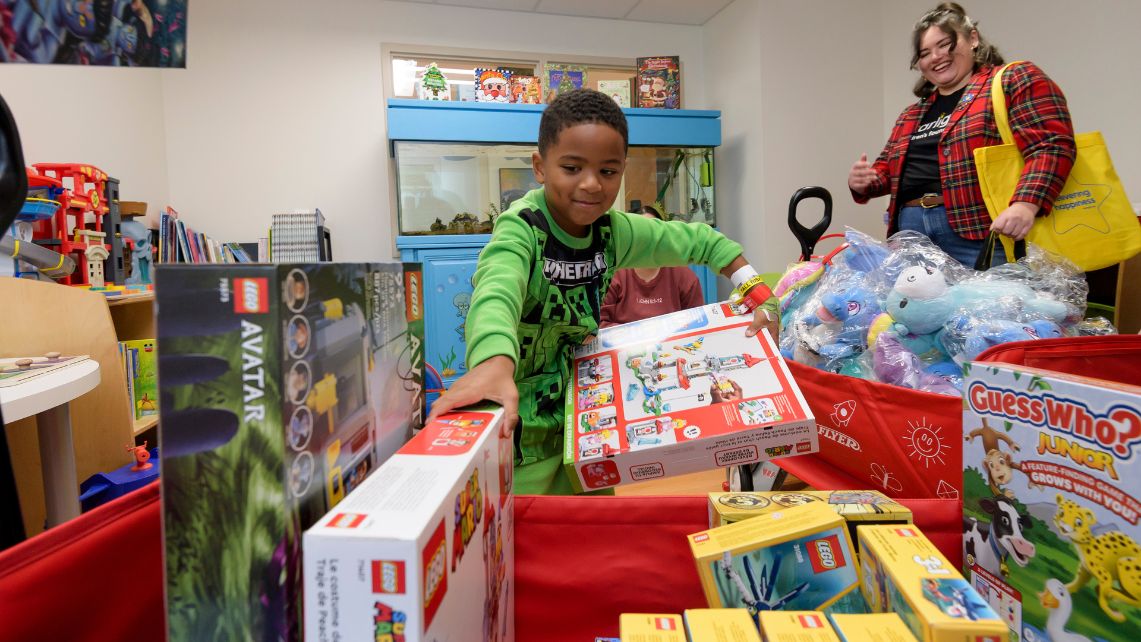 A UTMB pediatric patient chooses a Lego set out of a wagon of toys brought to UTMB by Tantrum Merch and nonprofit Starlight Children’s Foundation