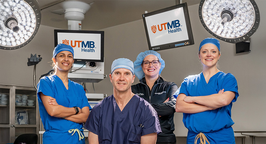 Three women and one man in blue scrubs