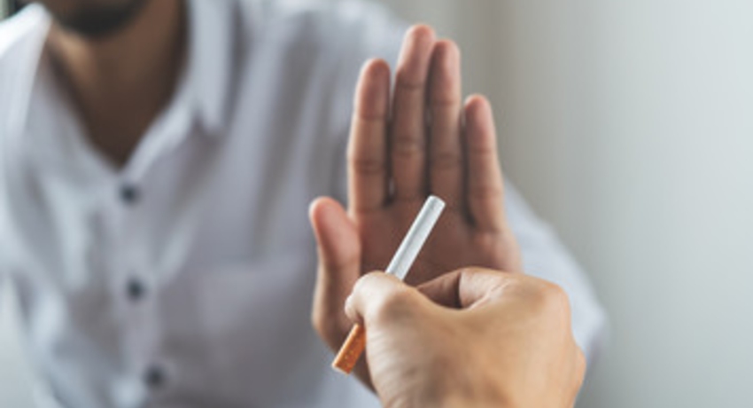 Close up person's hand offering a cigarette and another person saying no
